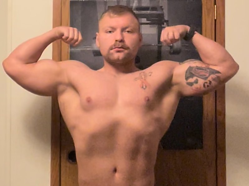 Michael from the waist up in a front double biceps pose, January 2023.